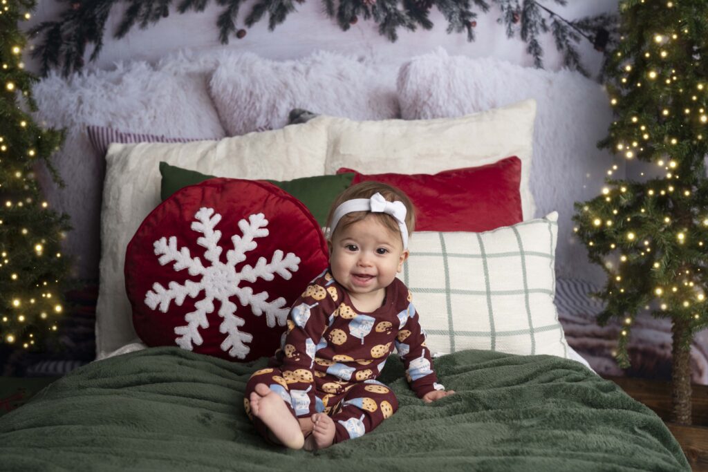 christmas mini session with pjs. little baby on bed with cookie theme pajamas